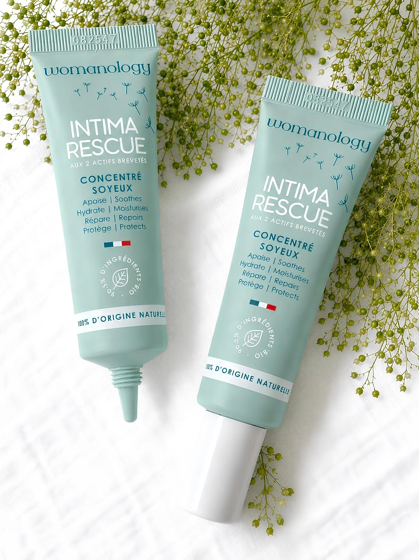 Două tuburi Intima Rescue de 20 ml, Womanology, pe un fundal cu flori